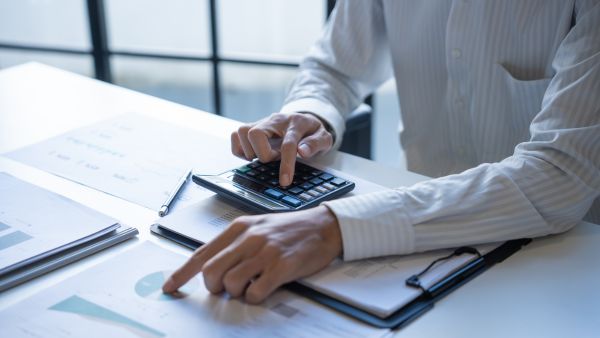 An auditor checking figures with a calculator. An auditor checking figures with a calculator.